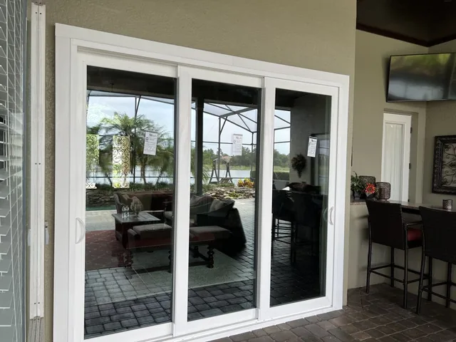 White three-panel sliding glass door beside a covered patio.