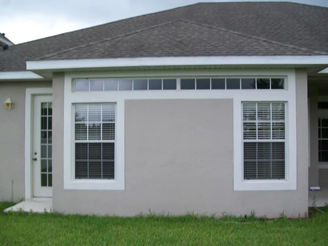Two white-framed windows below a narrow transom window.