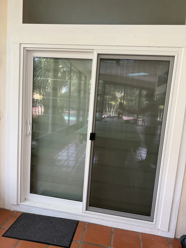 White-framed sliding glass door and screen installed by Tom at the homeowner’s covered patio.