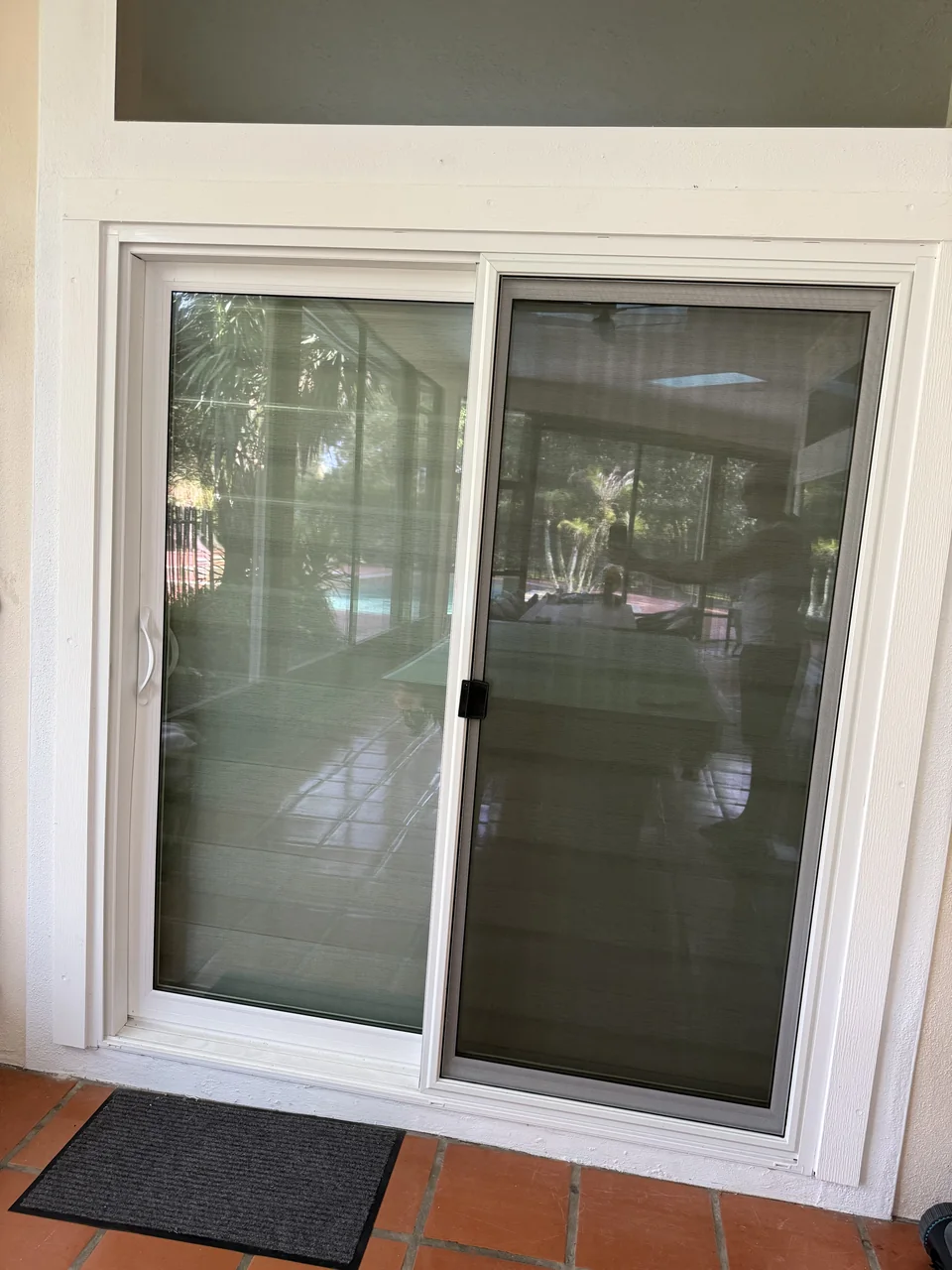 White-framed sliding glass door installed by Tom Davy at a homeowner’s covered patio