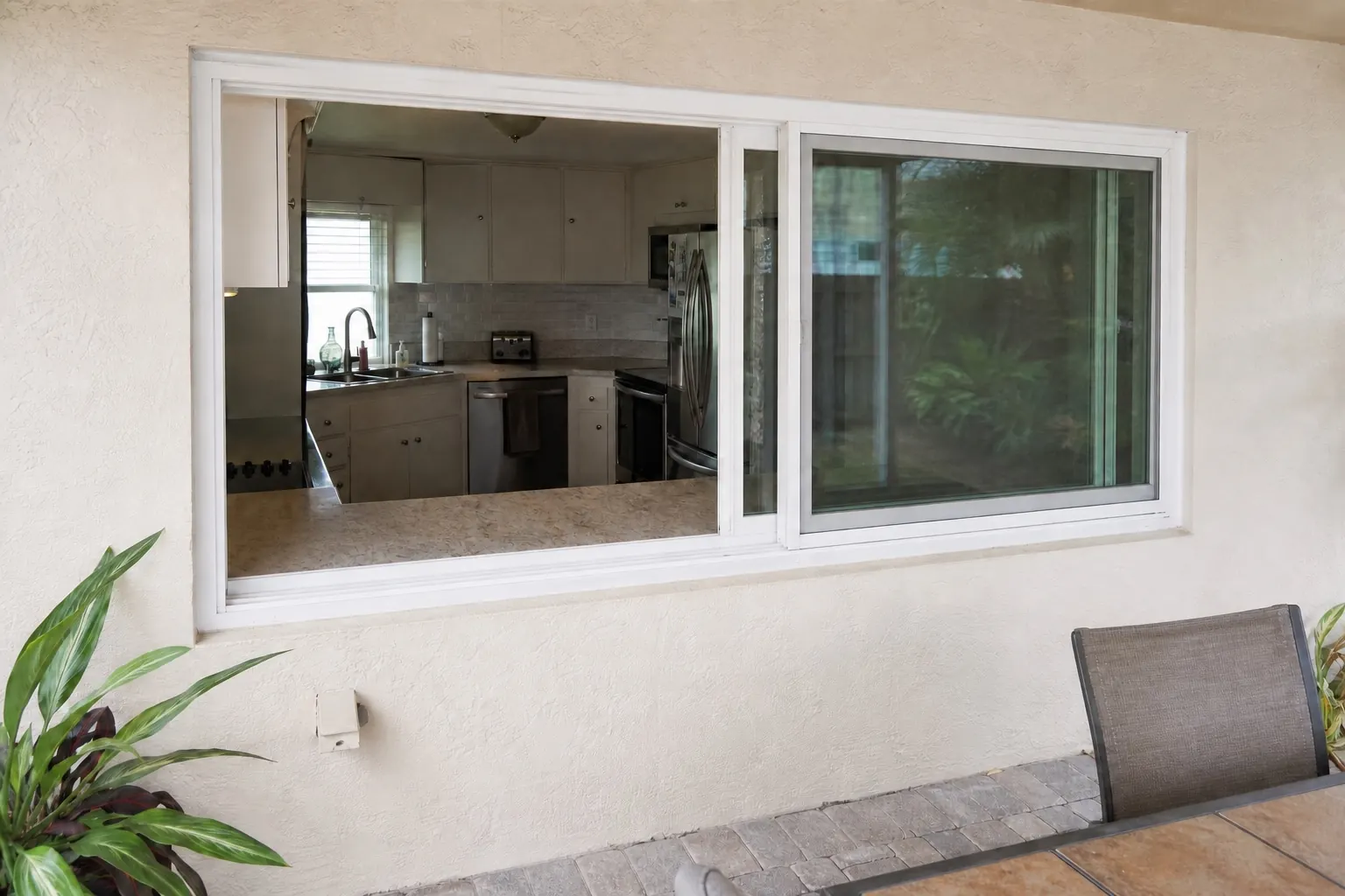 Open kitchen slider window viewed from a covered patio
